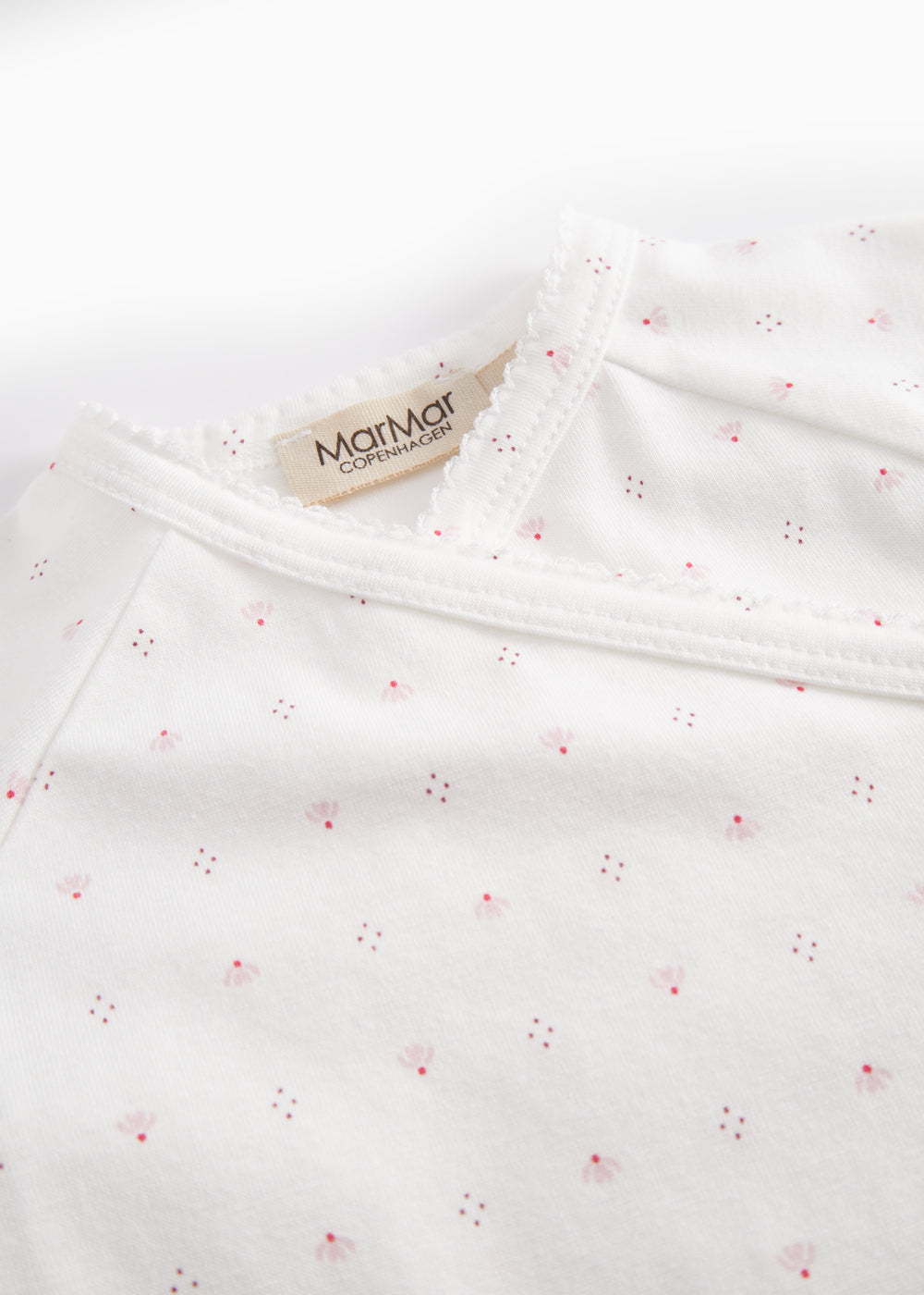 White baby romper without legs with fine floral pattern
