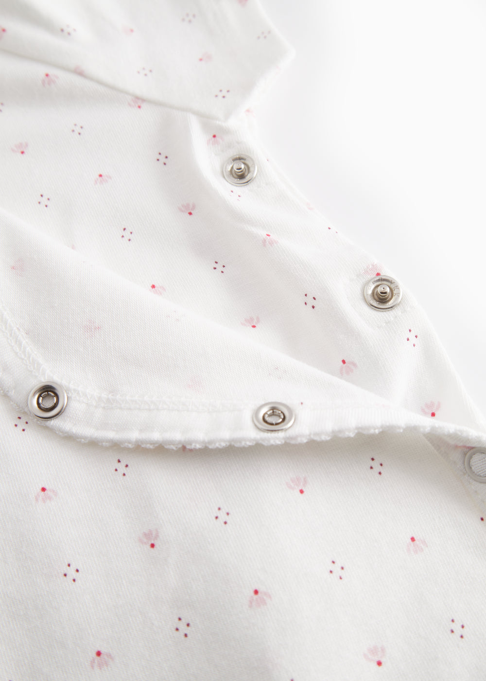 White baby romper without legs with fine floral pattern