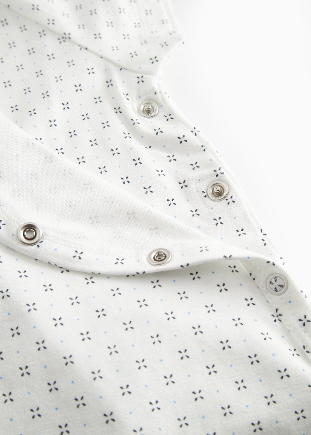 White baby sleepsuit without legs with fine pattern