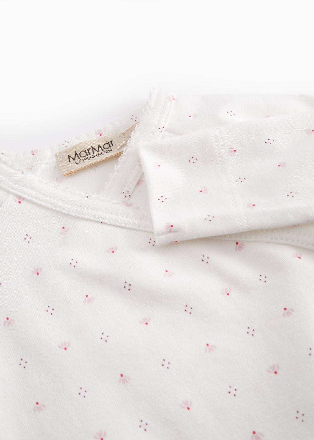 White baby all-in-one with feet in fine floral pattern