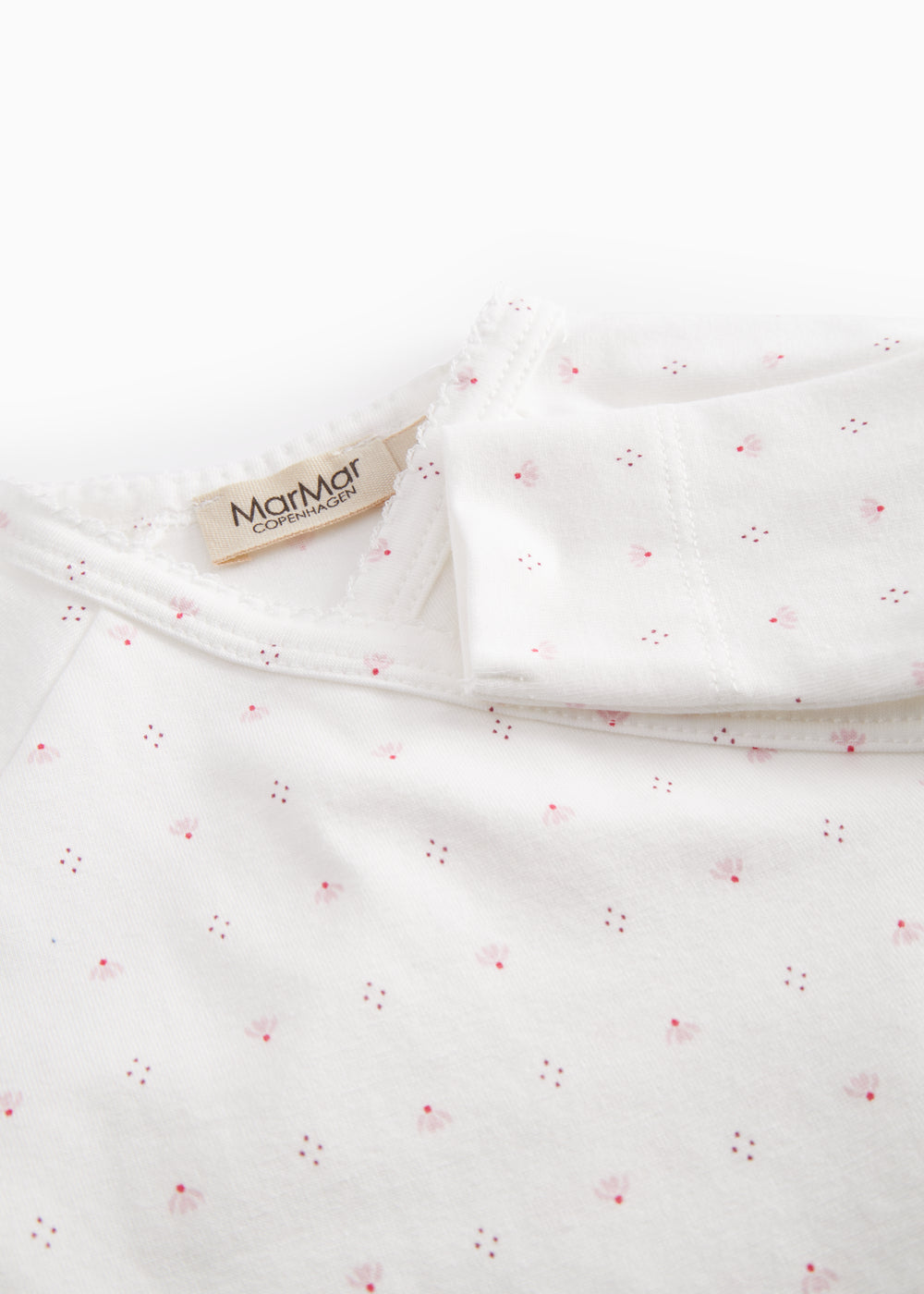 White baby all-in-one with wrap-around closure and small flowers