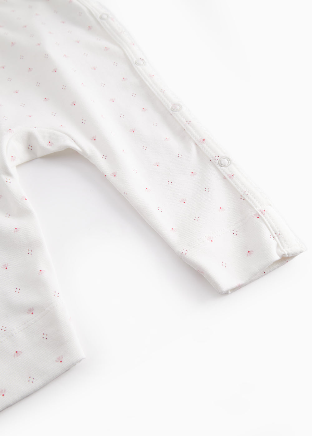 White baby all-in-one with wrap-around closure and small flowers