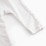 White baby all-in-one with wrap-around closure and small flowers