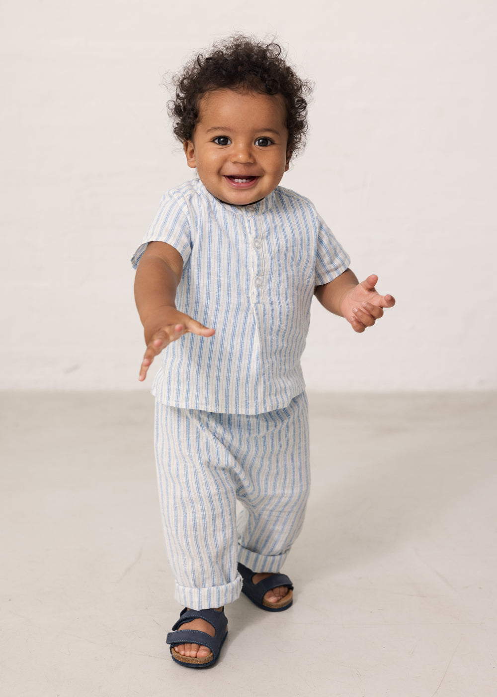 Baby i lyseblå stribede bukser og matchende skjorte