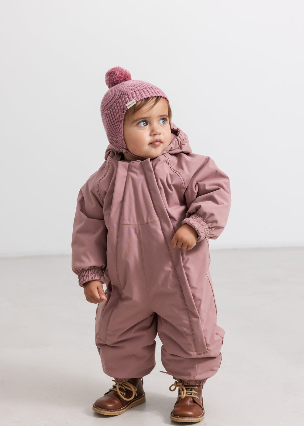 Stripe with pom-pom in rose brown color and ribbed edge.