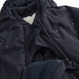 Black jumpsuit with visible zipper, fleece lining, and small reflective dots.