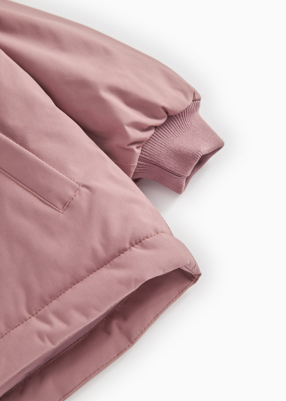 Winter jacket sleeves with ribbing and wind‑resistant seam in dusty rose