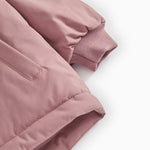 Winter jacket sleeves with ribbing and wind‑resistant seam in dusty rose