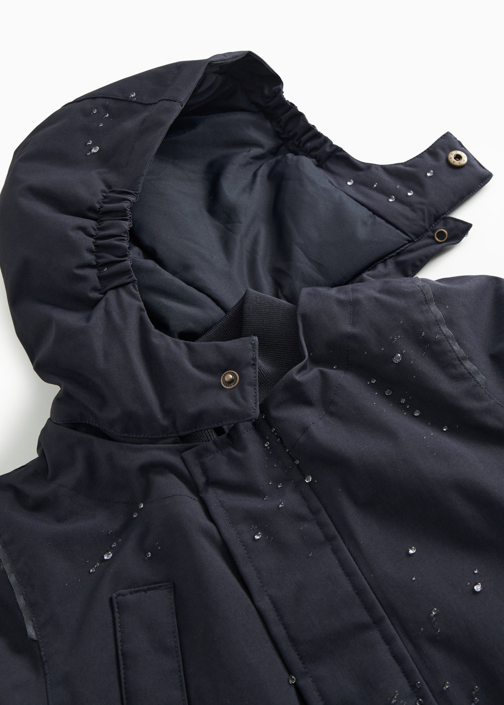 Winter jacket in dark navy with lined interior and snap buttons on the sleeves.