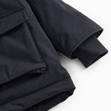 Winter jacket in dark navy with ribbed cuff and slanted seam at the bottom.