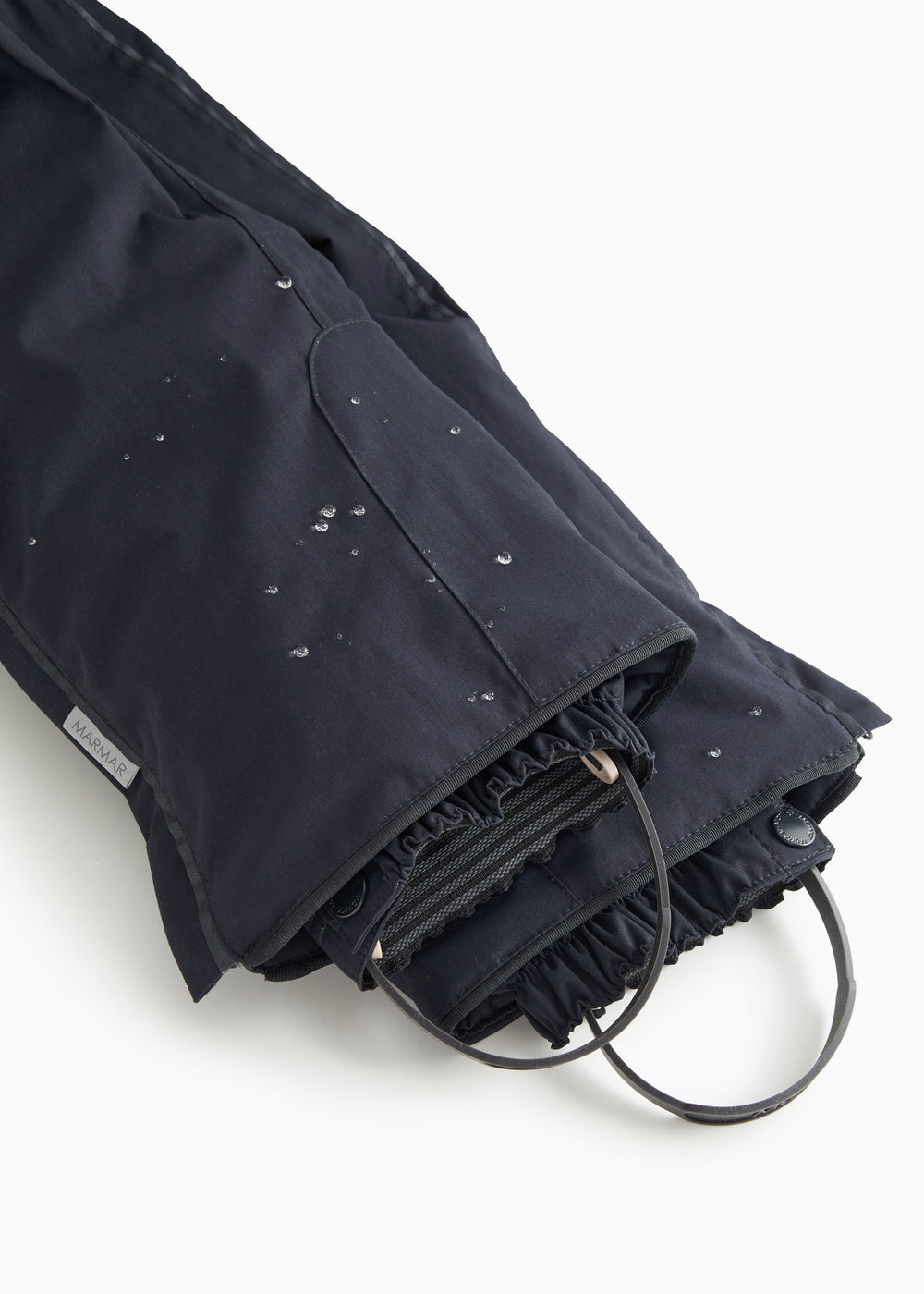 Dark overlay trousers with visible cords and front leg openings.
