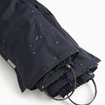Dark overlay trousers with visible cords and front leg openings.