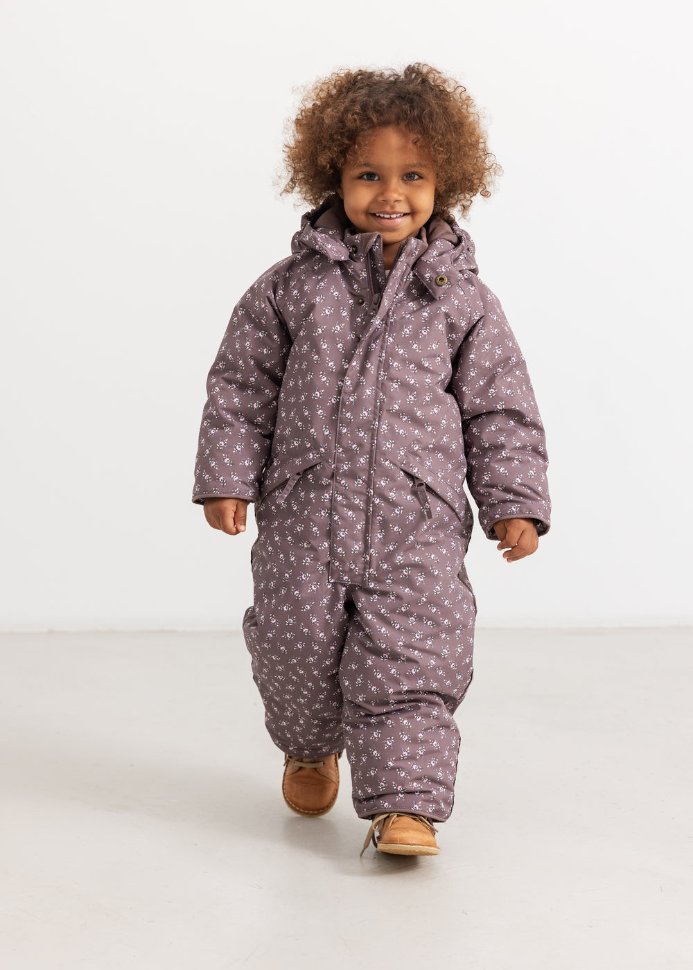 Dark brown jumpsuit with hood and zipper; small floral print.