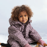 Baby in dusty pink gloves with ribbed cuffs on the hands.