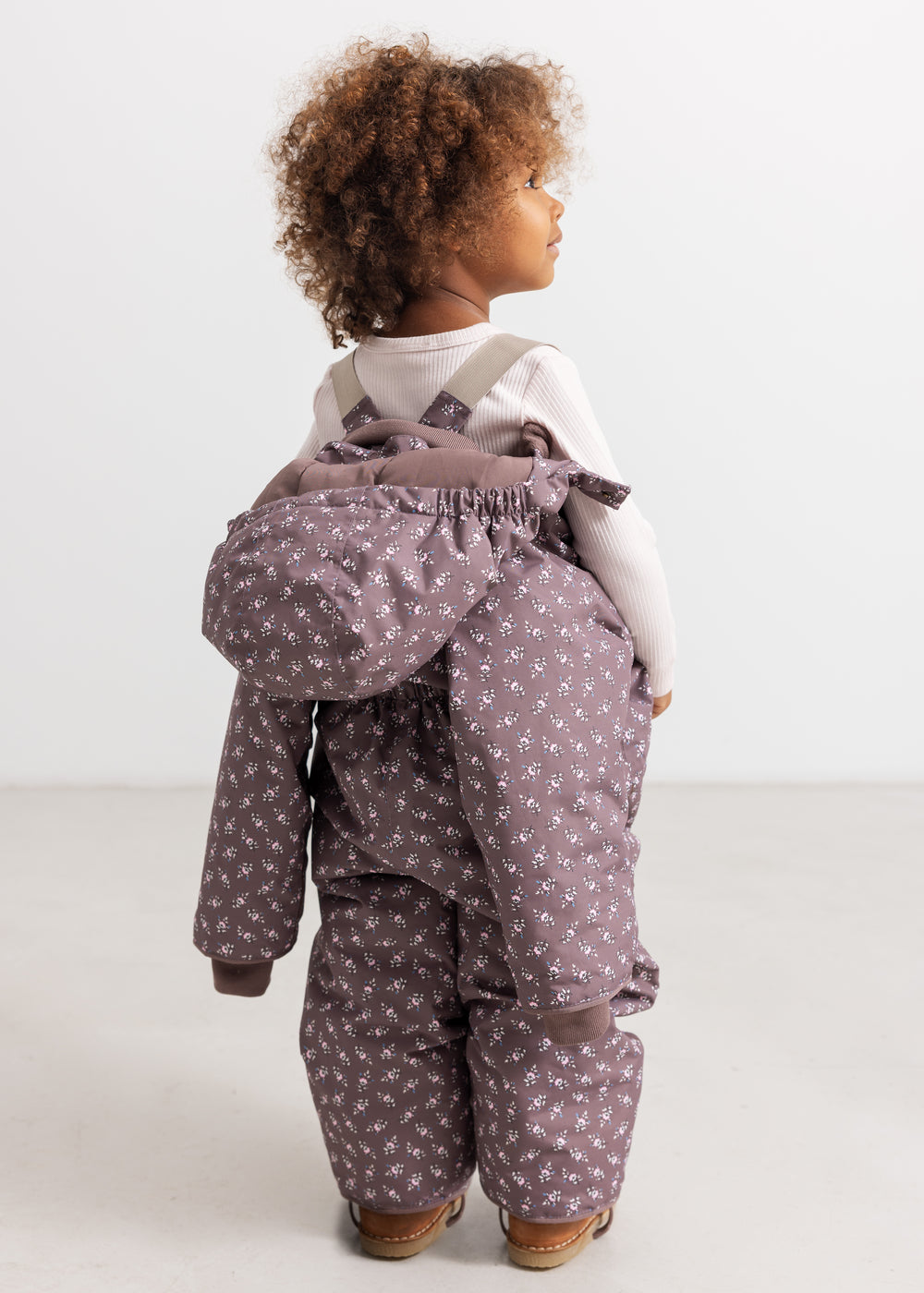 Lil suit with hood and small flower print, zipper and adjustable waist.