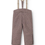 Dark brown overalls with small white flowers, straps and elastic at the legs.