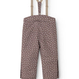 Dark brown overalls with small white flowers, straps and elastic at the legs.