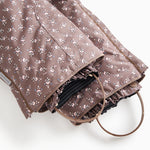 Fold-over pants with creased hem and dark brown floral print, elastic at the leg opening.