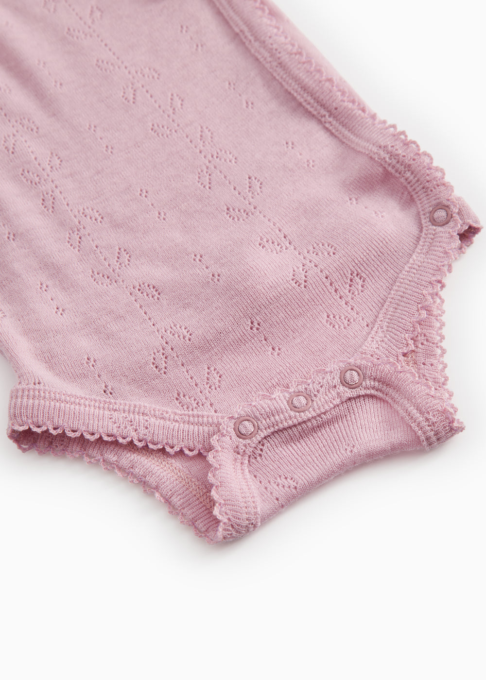 Pink bodystocking with openwork pattern, trim, and snap closure at the crotch.