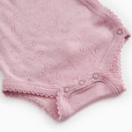 Pink bodystocking with openwork pattern, trim, and snap closure at the crotch.