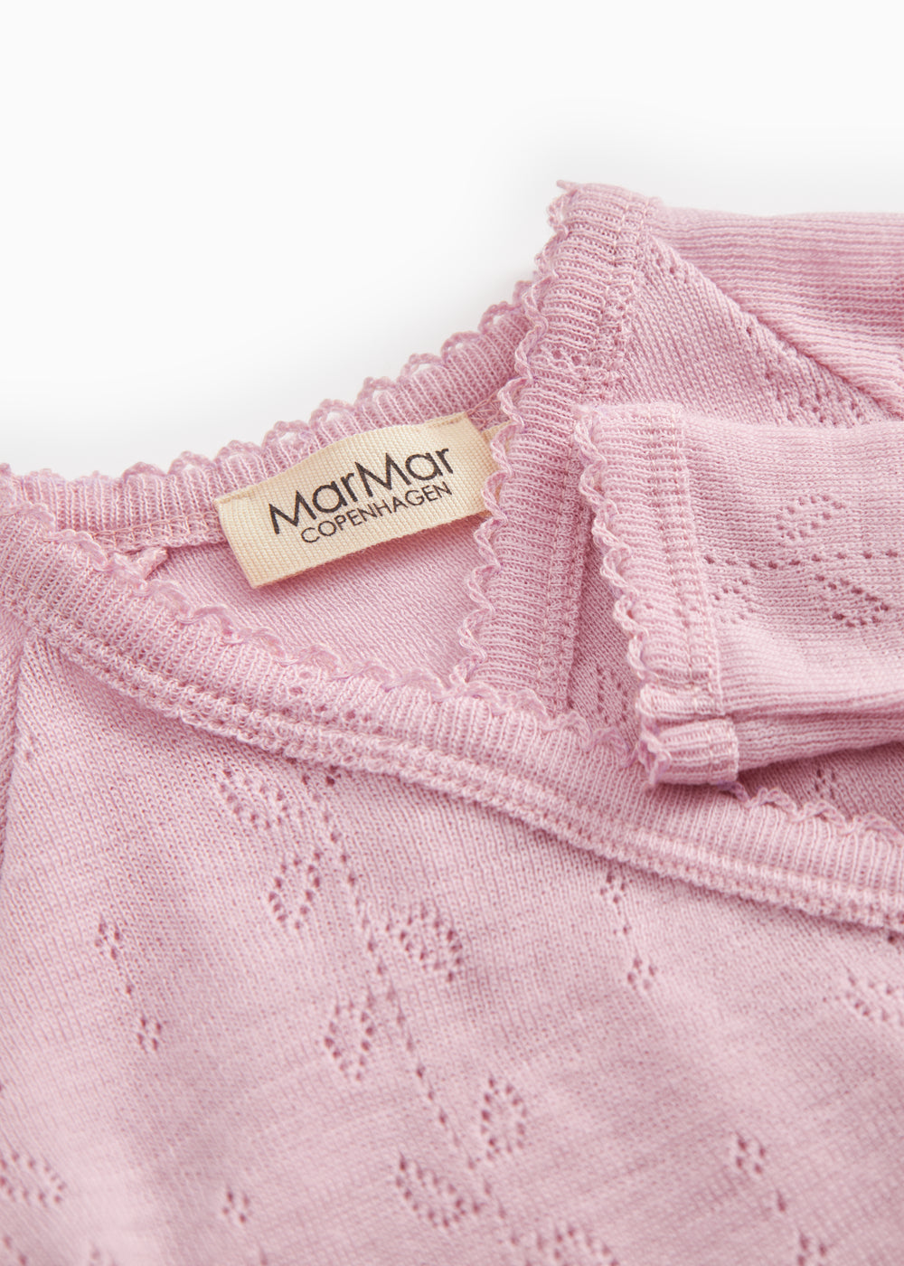 Pink baby jumpsuit with MaMaGar brand and fine perforated texture.