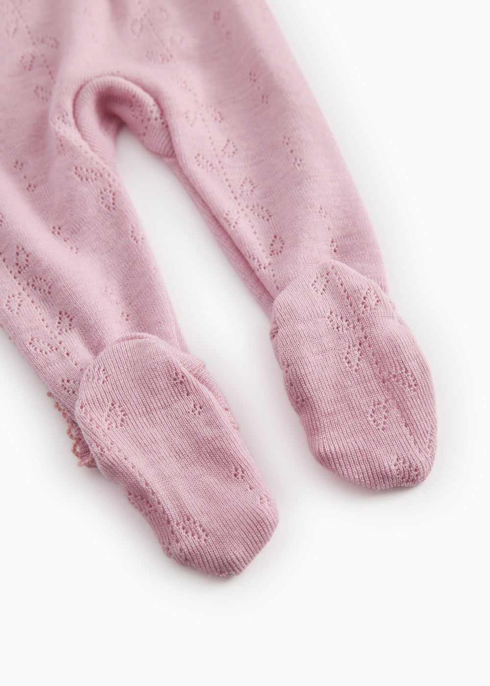 Pink jumpsuit for baby, ribbed cuffs at the feet and a finely cut pattern.
