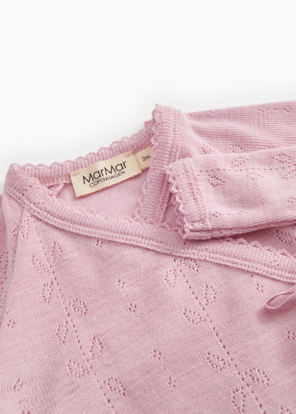 Pink baby jumpsuit with ribbed collar, fabric pattern, and MaMMar logo on the brand.