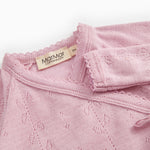 Pink baby jumpsuit with ribbed collar, fabric pattern, and MaMMar logo on the brand.