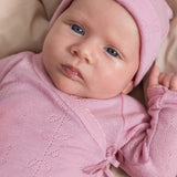 Pink knitted hat for baby with round top and fine knitted pattern