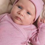 Pink bodystocking with openwork pattern, long sleeves and a ruffled detail at the neckline.