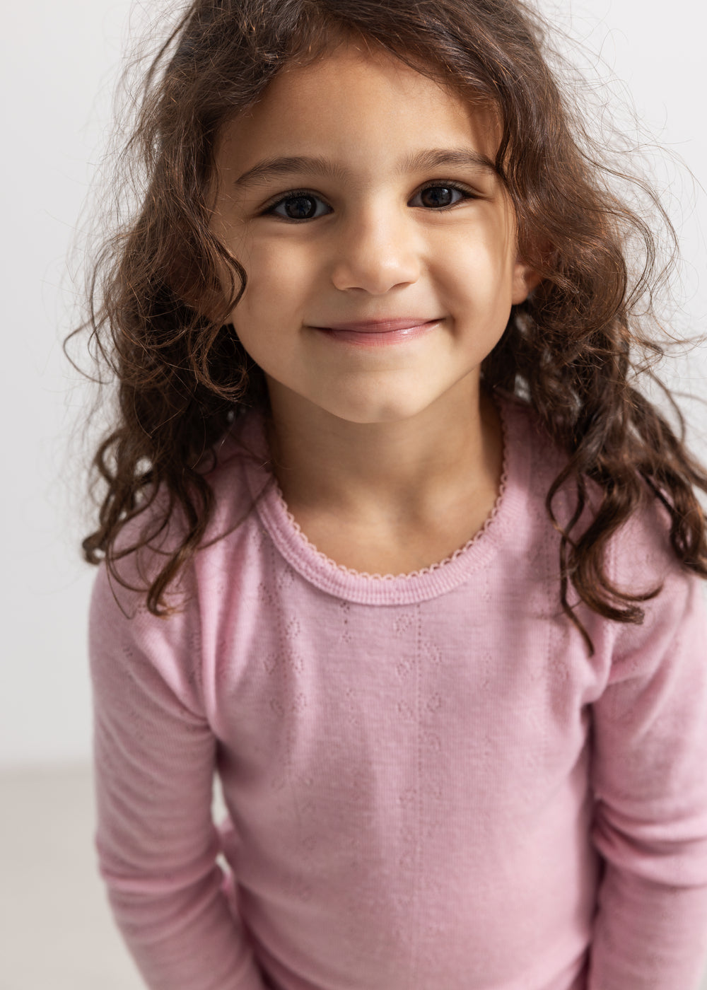 Tamra t-shirt in pink with long sleeves and a hole pattern for the child.