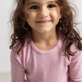Tamra t-shirt in pink with long sleeves and a hole pattern for the child.