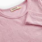 Pink t‑shirt with round neckline, eyelet pattern and visible inner label.