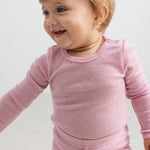 Pink bodystocking with long sleeves and a finely perforated texture for the child.