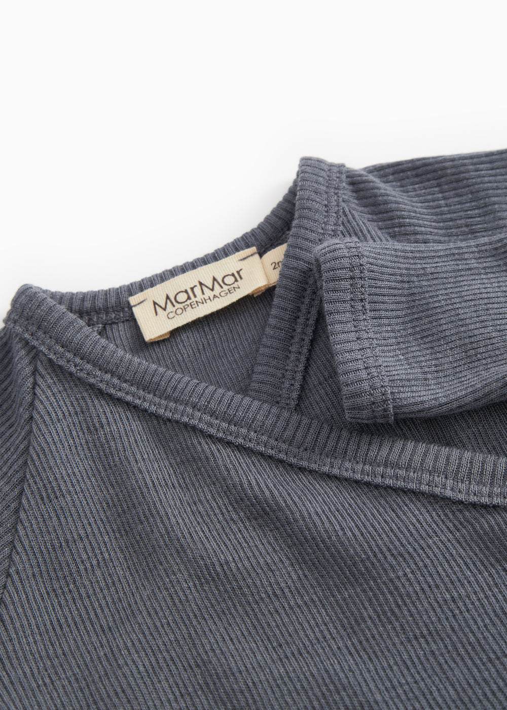 Dark gray jumpsuit with ribbed collar and visible inner label at the neck.