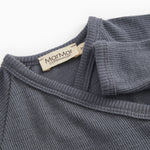 Dark gray jumpsuit with ribbed collar and visible inner label at the neck.