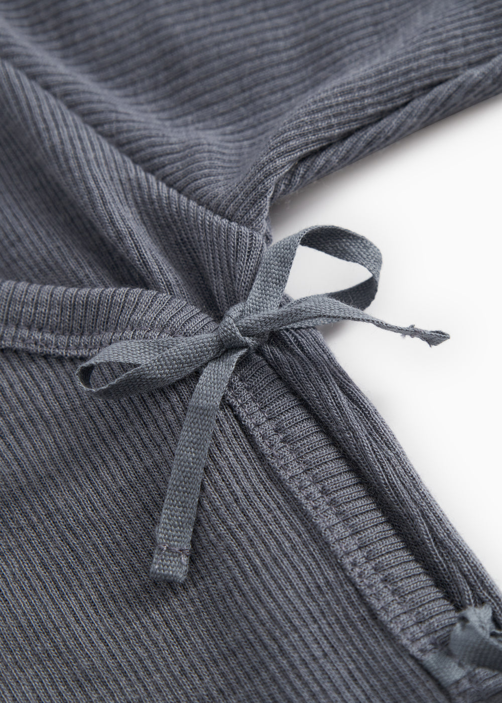 Dark gray jumpsuit with knot band in front and visible rib structure.
