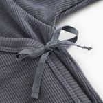 Dark gray jumpsuit with knot band in front and visible rib structure.