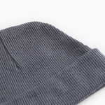 Close-up of a dark gray ribbed baby hat with a tight striped texture.