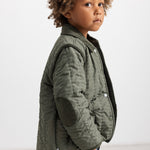 Olive green thermal jacket for children, quilted with snap closure and side pockets.