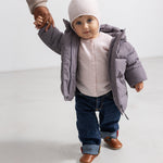 Pink baby cardigan with button closure, visible under a gray winter jacket.
