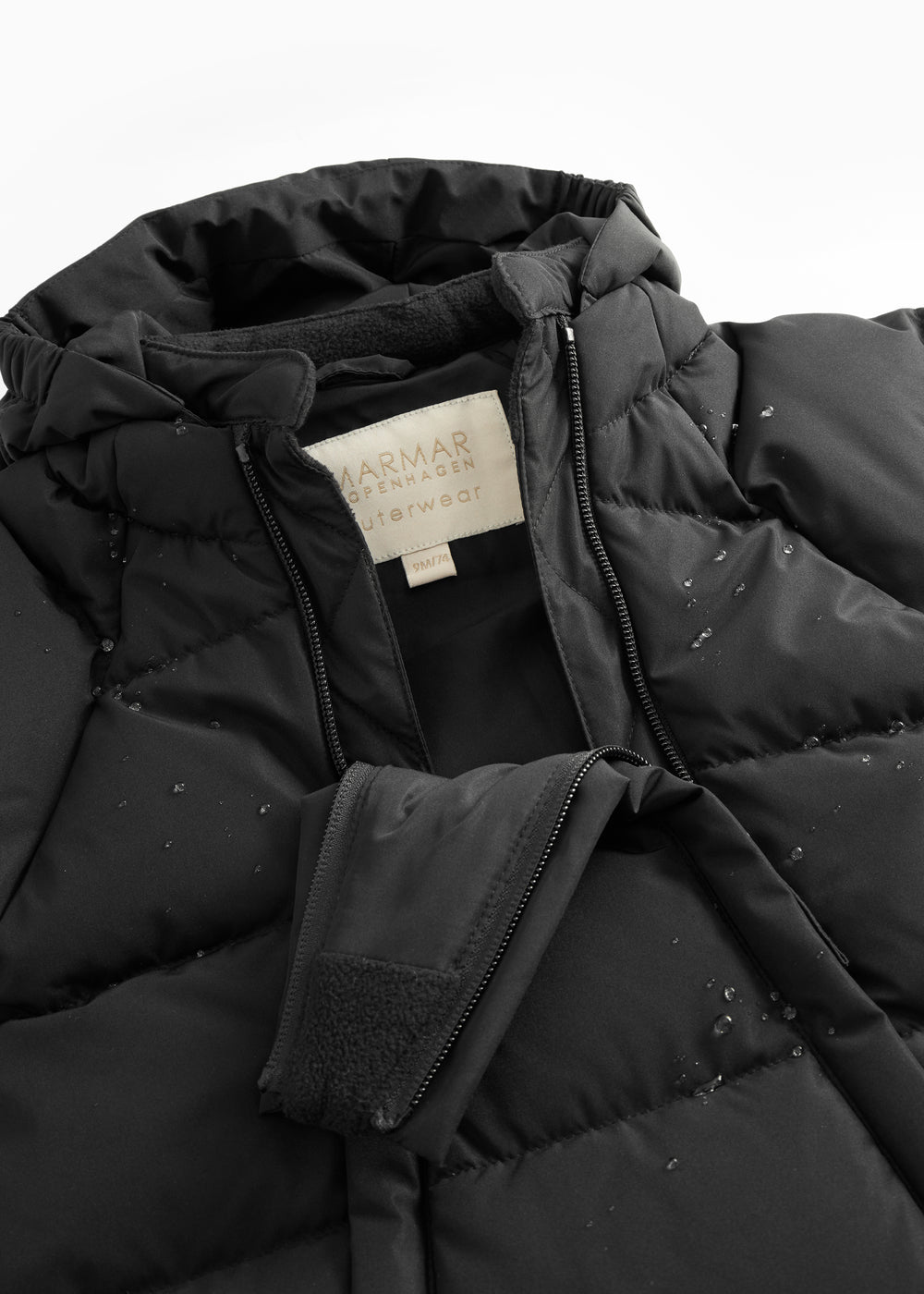 Sort puffer jacket with zipper and visible label on the chest.