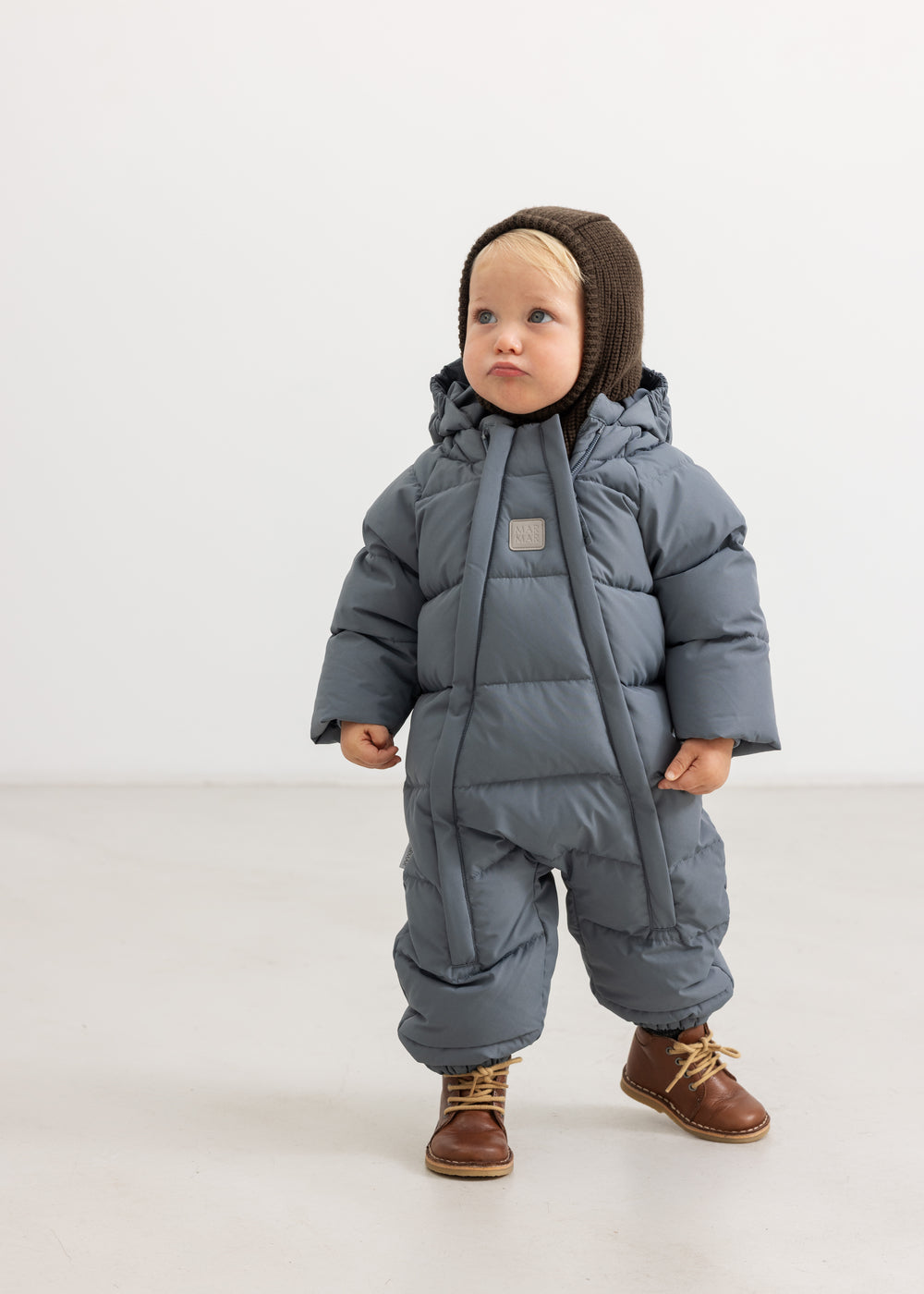 Dark brown knit cap with hood, ribbed and close-fitting edge around the face.