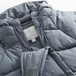 Dark gray jumpsuit with front zipper, sewn-in label, and small water droplets on the padding.