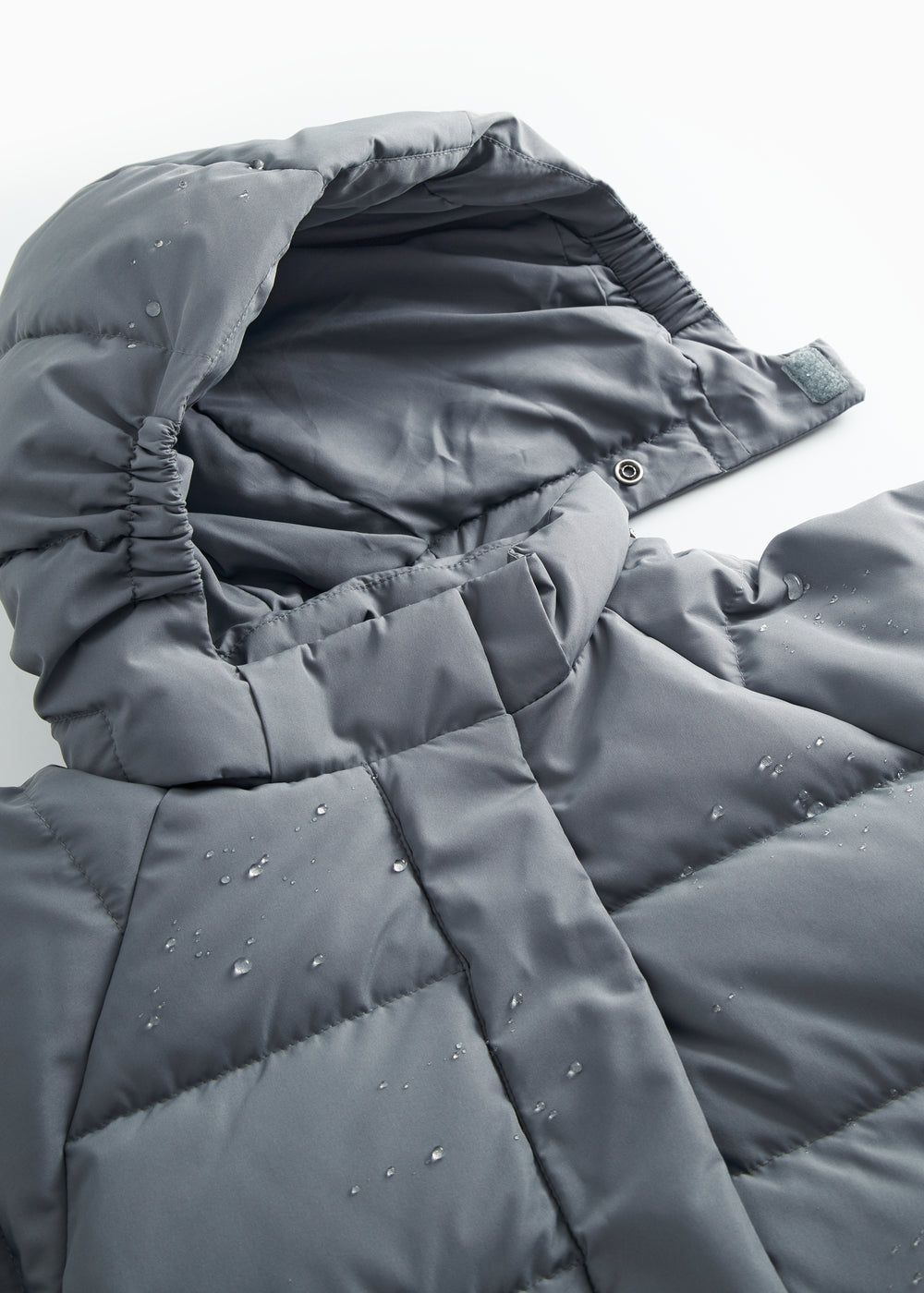 Dunjakkekrave and hættekant in dark gray with stitching and quilted filling.