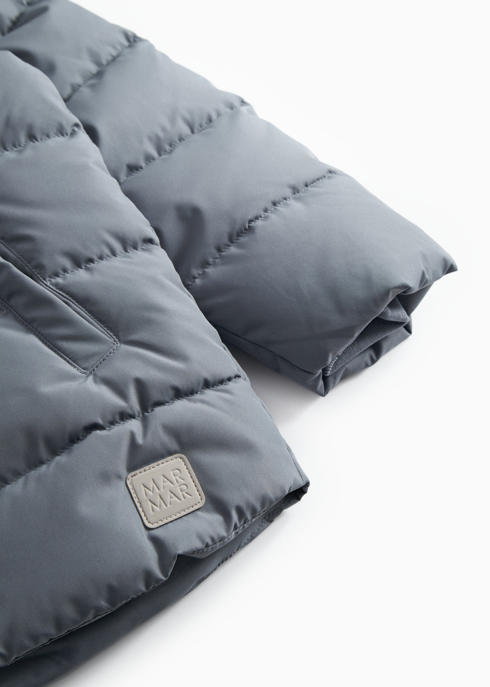 Gray down jacket for children with quilting, zipper, and a label patch at the bottom.