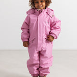 Pink striped hat on child in jumpsuit with hood