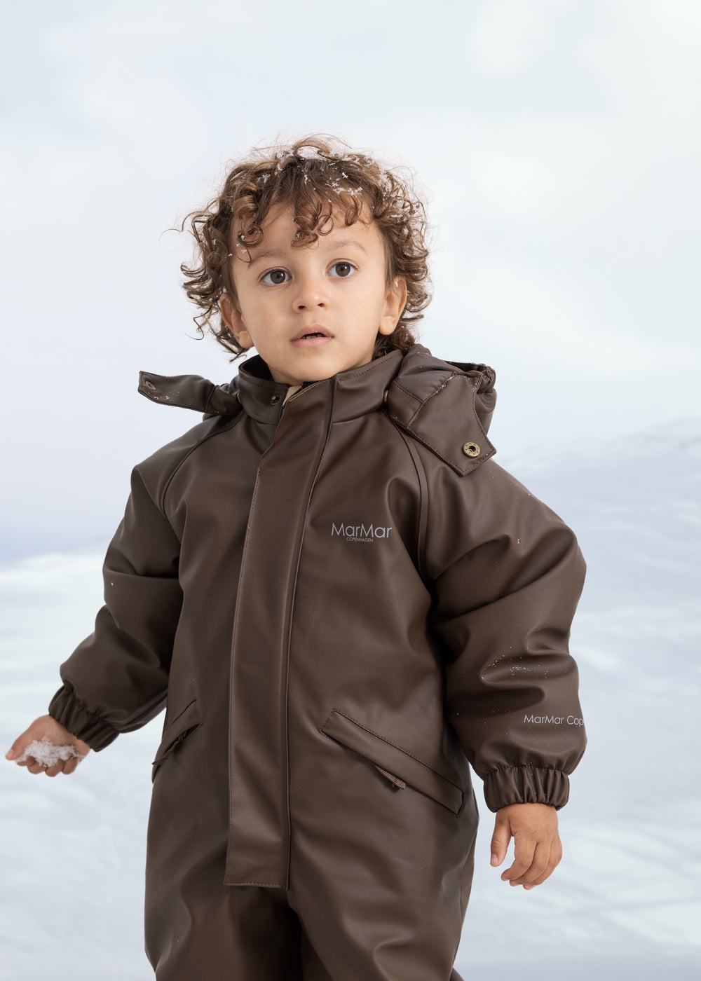 A flight suit in dark brown with hood and zipper, for children.