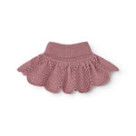 Knitted scarf with ribbed edge and wave pattern in muted rose color.