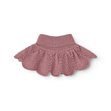 Knitted scarf with ribbed edge and wave pattern in muted rose color.